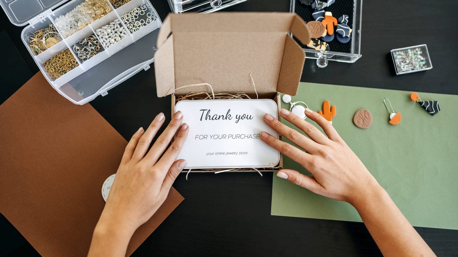 An open cardboard parcel with a handwritten thank-you card resting on tissue paper above the product inside
